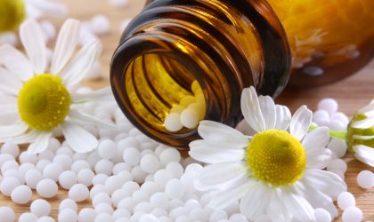 Bouteille de produits homéopathiques entourée de fleurs